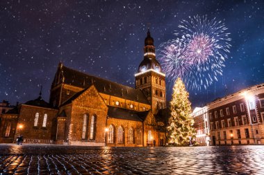Letonya, Riga 'daki Kubbe Meydanı' nda bulunan Noel ağacı. Güzel bir gece gökyüzü ve Riga 'nın eski kasabasında havai fişekler. Noel Baba Noel ağacının yanında çocukları bekliyor..