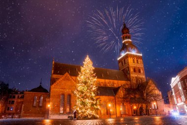 Letonya, Riga 'daki Kubbe Meydanı' nda bulunan Noel ağacı. Güzel bir gece gökyüzü ve Riga 'nın eski kasabasında havai fişekler. Noel Baba Noel ağacının yanında çocukları bekliyor..