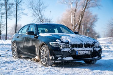 Riga, Latvia. January 10, 2021. BMW G20 320 model covered in snow parked alone in the parking lot.