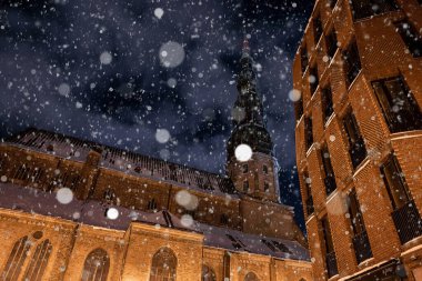 Night view of the St. Peters cathedral in Riga, Latvia. Beautiful snow in the old town of Riga.
