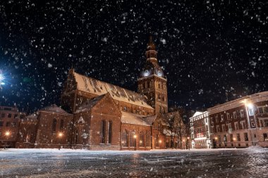 February 10, 2021. Riga, Latvia. Beautiful winter night in the old town of Riga, Latvia. Statue of liberty Milda covered in snow at night.
