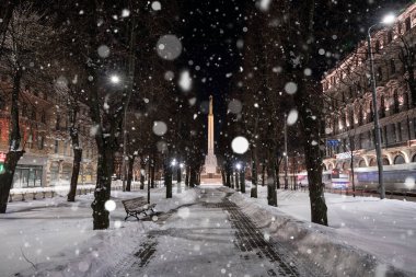 February 10, 2021. Riga, Latvia. Beautiful winter night in the old town of Riga, Latvia. Statue of liberty Milda covered in snow at night.