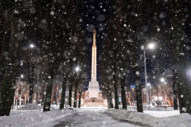 February 10, 2021. Riga, Latvia. Beautiful winter night in the old town of Riga, Latvia. Statue of liberty Milda covered in snow at night.