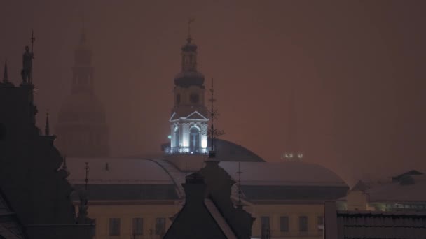 Erős havazás Rigában az óvárosban éjszaka. Havazik a város felett. — Stock videók