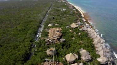 Tulum 'daki Azulik otelinin hava manzarası. Deniz kıyısındaki ormandaki eko ahşap evlerin güzel manzarası..