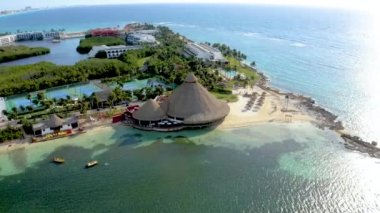 Beautiful aerial view of the beaches in Mexico near Cancun. Flying over luxury hotels bungalow, turquoise blue water and palm trees.