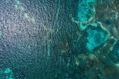 Dalgalar ve köpükle birlikte turkuaz mavi deniz dokusu. Karayip renkleri. Arkaplan fotoğrafı.