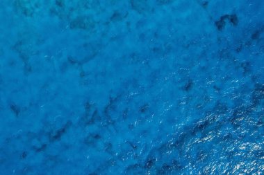 Dalgalar ve köpükle birlikte turkuaz mavi deniz dokusu. Karayip renkleri. Arkaplan fotoğrafı.