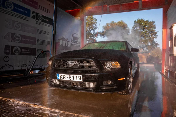 Negro Ford Mustang coche muscular en un lavado de coches. — Foto de Stock