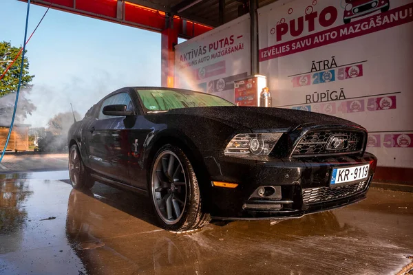 Negro Ford Mustang coche muscular en un lavado de coches. — Foto de Stock