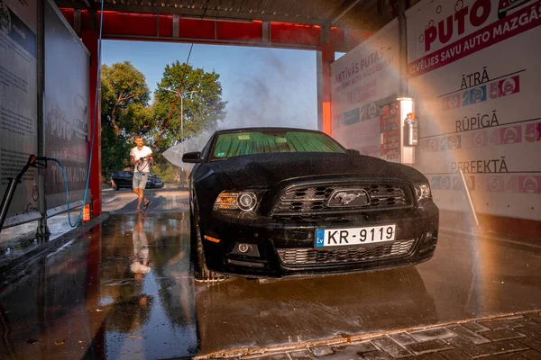 Negro Ford Mustang coche muscular en un lavado de coches. — Foto de Stock