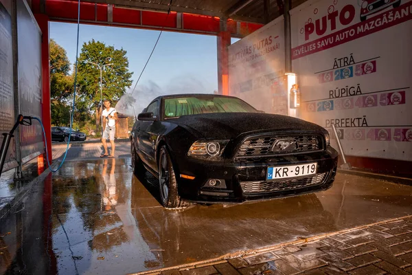 Negro Ford Mustang coche muscular en un lavado de coches. — Foto de Stock