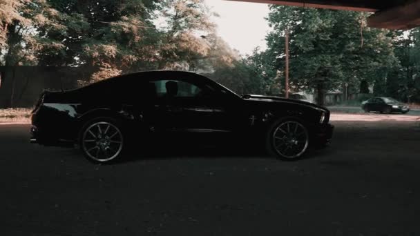 검은 포드 머스탱 모델은 먼지가 많은 도로 위를 떠다니며 타이어를 태우는 모습. — 비디오