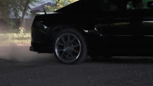 Zwarte Ford Mustang model drijven en branden banden op een stoffige weg. — Stockvideo