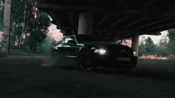 Ford Mustang negro modelo a la deriva y la quema de neumáticos en un camino polvoriento. — Vídeos de Stock