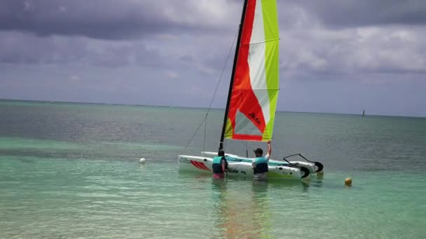 Scenic view at small catamaran with yellow green blue sail sailing in sea. — Vídeos de Stock