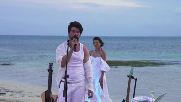 Alina Astrovskaja e Anton Lavrentev realizando show ao vivo em uma praia — Vídeo de Stock