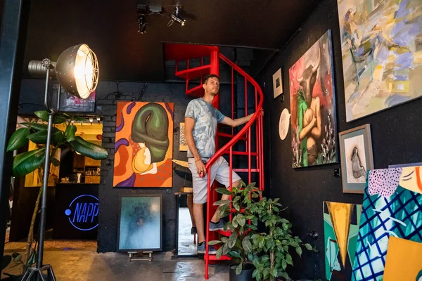 Young man exploring art gallery in a coffee shop. — Fotografia de Stock