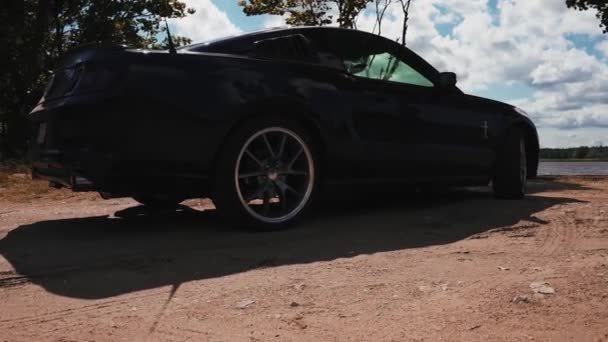 Μαύρο Ford Mustang μοντέλο σταθμευμένο. Αθλητισμός θρυλικό αμερικανικό σπορ αυτοκίνητο — Αρχείο Βίντεο