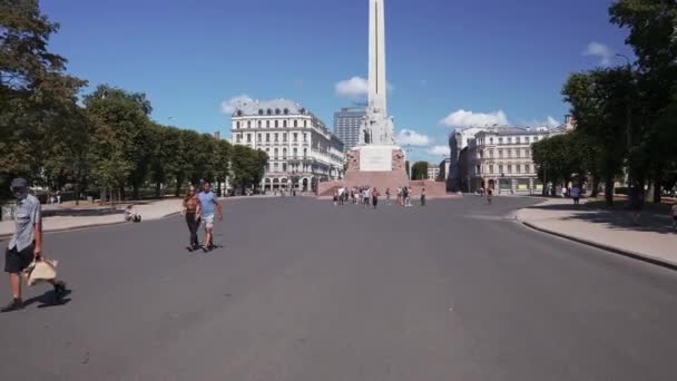 Pasando por el casco antiguo de Riga cerca de la estatua del monumento y entrar en el parque. — Vídeo de stock