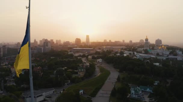 Vista aérea da bandeira ucraniana acenando ao vento contra a cidade de Kiev — Vídeo de Stock