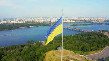 Ukrayna bayrağının rüzgarda dalgalanan havadan görünüşü Kyiv şehrine karşı