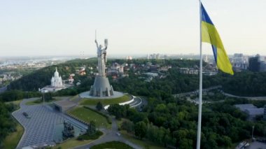 Ukrayna bayrağının rüzgarda dalgalanan havadan görünüşü Kyiv şehrine karşı