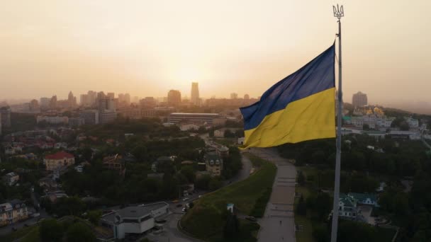 Vista aérea de la bandera ucraniana ondeando en el viento contra la ciudad de Kiev — Vídeo de stock