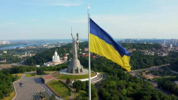 Aerial view of the Ukrainian flag waving in the wind against the city of Kyiv — Stock Video