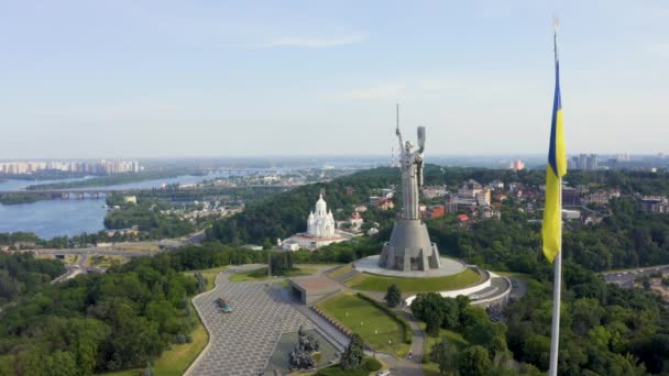 Vista aérea de la bandera ucraniana ondeando en el viento contra la ciudad de Kiev — Vídeos de Stock