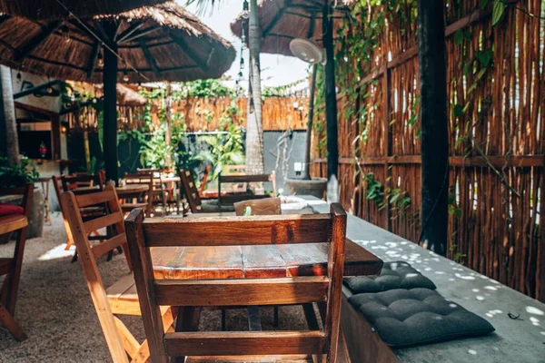 옥외 카페에는 텅 빈 나무 의자와 탁자와 짚으로 만든 우산이 놓여 있다 — 스톡 사진