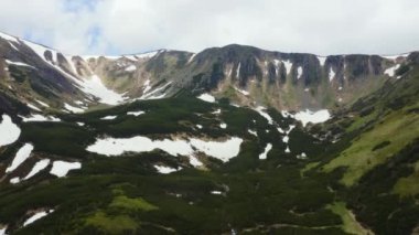 Renkli bahar günbatımının dağ sıraları üzerindeki hava manzarası.