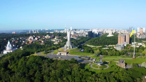 Вид с воздуха на украинский флаг, размахивающий ветром против города Киева — стоковое видео