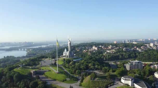 Вигляд з повітря на український прапор, що махає вітром проти міста Києва. — стокове відео