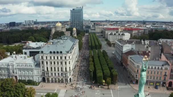 Vista aérea sobre a multidão de pessoas que estão correndo uma maratona em Riga. — Vídeo de Stock