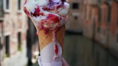 Gondollara karşı waffle külahında dondurmalı dondurma tutan bir el.