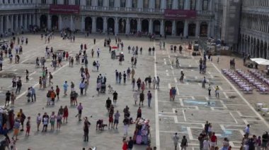 İnsanlar güneşli bir yaz gününde Venedik 'te St Marks Meydanı' nda yürürler.. 