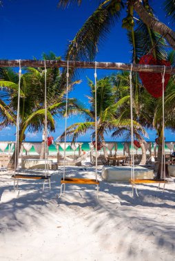 Kadın turistle boş salıncak koltukları sahilde boş zamanlarını geçiriyorlar.