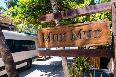 Ahşap Mur Restoran tabelası yol kenarında asılı.