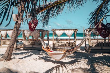 Hamakta dinlenen bir kadın Güzel bir plaj tatil köyünde