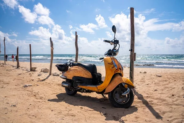 Gelber Motorroller, der an einem sonnigen Tag am Strand auf Sand geparkt ist — Stockfoto