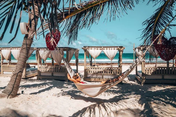 Hamakta dinlenen bir kadın Güzel bir plaj tatil köyünde — Stok fotoğraf