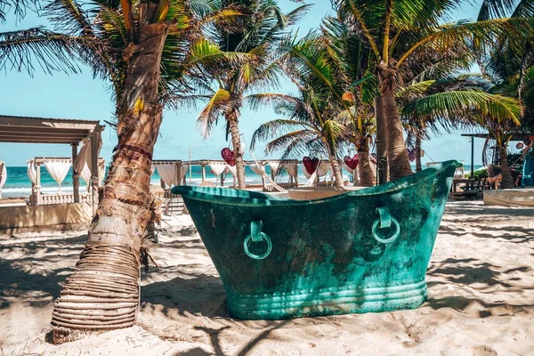 复古风格金属浴缸在海滨度假胜地与心形艺术品挂在树上 — 图库照片