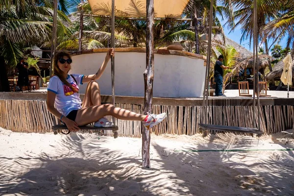 Beautiful woman having fun sitting on swing at mexican resort — Stock Photo, Image