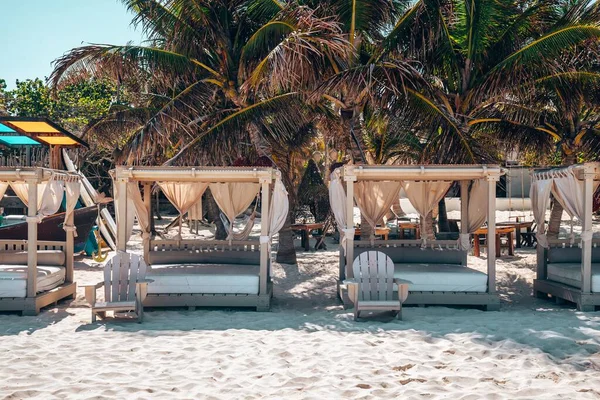 Puste leżaki plażowe z drewnianymi krzesłami na piasku w pięknym kurorcie — Zdjęcie stockowe