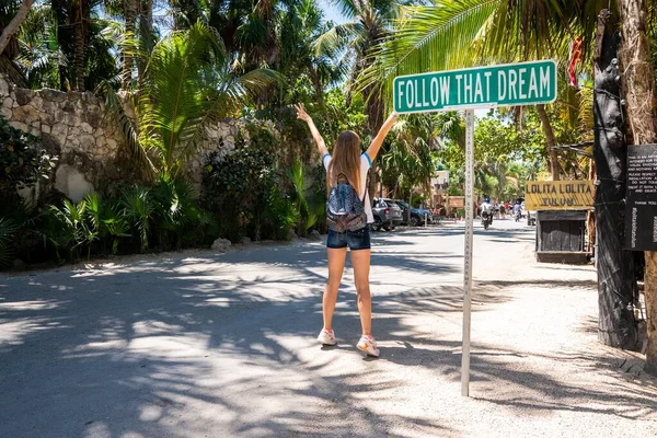 Female tourist posing by motivational sign at roadside — Stock Photo, Image