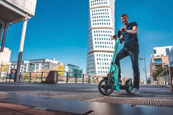 Malmö sokaklarında elektrikli scooter süren genç bir adam.. — Stok fotoğraf