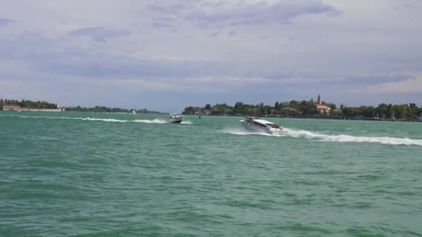 Лодки, проходящие мимо Венецианской лагуны с волшебной площадью Святого Марко, видимой на горизонте. — стоковое видео