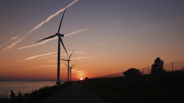 Des éoliennes au coucher du soleil. Production d'énergie écologique verte. — Video