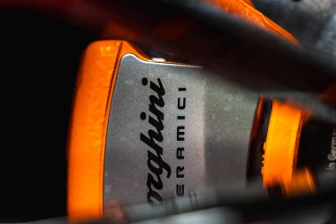 Lamborghini CERAMICI markası, canlı turuncu aksanı ve metalik işçiliğin yer aldığı Lamborghini Urus fren kalibresinin ayrıntılı görüntüsü.